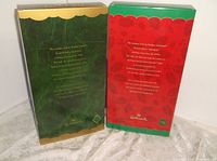 Back side views of the green 1997 Holiday Voyage box with gold trim and the red and green 1998 Holiday Sensation box with holiday floral decoration and Hallmark branding