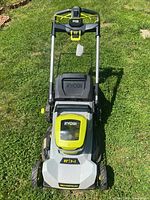 Front view of Ryobi mower showing handle, deck, and wheels