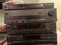 Stacked view of four Technics stereo components: CD changer, equalizer, amplifier, and tuner.