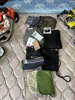 Top view of assorted cloth bags and travel accessories arranged on mattress