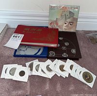 Overall view of all coin albums, currency book, display folder and loose coins on carpet