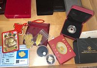 Wide view of all lot items including coins, medallions, charms and presentation boxes