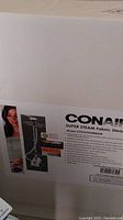 Box showing Conair Super Steam fabric steamer model CTXGS95WBHR, with feature highlights including 40% hotter steam and 3x faster steaming.