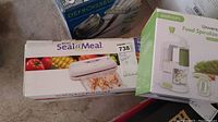 Boxes of Rival Seal-a-Meal food sealer and Sedhoom Universal Food Spiralizer with packaging visible