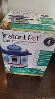 Box of Pioneer Woman Instant Pot Lux 6-in-1 Multi-Use Programmable Pressure Cooker showing branding, floral design, and product features.