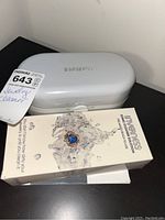 Photo of white Inverness branded jewellery ultrasonic cleaner unit with control dial and the boxed Inverness Sonic Cleaner Solution in front.