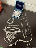 Photo showing the full spread of silver and silver plated jewellery items including bracelets, necklaces, a ring, and earrings.