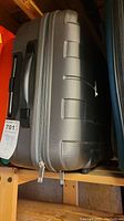 Gray hard shell suitcase viewed from the top showing zipper and handle