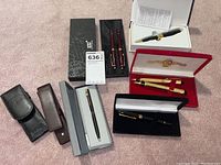 Overview of all promotional pens, sets, pouches and cases laid out on floor