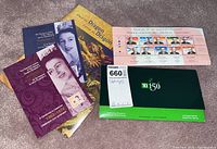 Photo displaying five packages of stamps including commemorative collections featuring Queen Elizabeth II, Year of the Dragon 2000, Premiers of Canadian Provinces, and TD 150 commemorative stamp booklets.