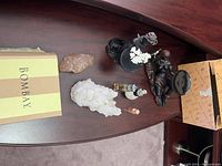 Top angled view of crystals, figurines, bottles, and Bombay box arranged on a wood table