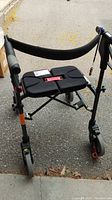 Side and angled view of Nexus walker showing foldable frame, padded seat, and front wheels.