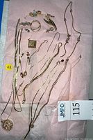 Overhead shot of all jewelry items laid on pink paper