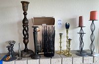 Full view of the candleholders assortment on a mantle, showing variety in styles and materials, from smallest 5" to tallest about 20"