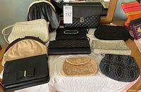 Lot of 11 assorted clutch purses placed on a white surface, showing variety in colors and styles including black, beige, white, and quilted black purse with gold clasp.