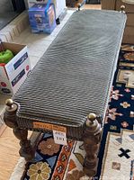 Full view of the corduroy bench showing the wood frame, brass finials on the corners, and the corduroy fabric upholstery.