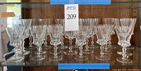 Photo of 21 Gorham crystal stemmed goblets on glass shelf, 11 water glasses and 10 wine glasses grouped together