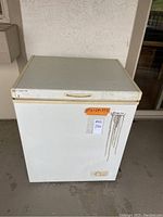 Closed Magic Chef chest freezer with visible manufacturer label and size markings.