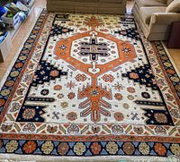 Full view of the large area rug laid out on the hardwood floor between two beige sofas, showing central medallion and border patterns.