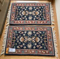 Two matching rectangular wool rugs placed one above the other, showcasing overall floral design and condition.