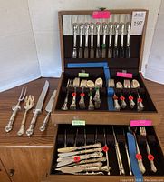 Overview of wooden storage case with open drawers and additional utensils laid out