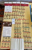 Overhead view of laid-out coin sets and leaflets on table