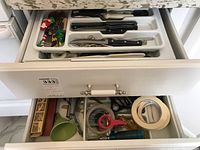 Both drawers showing kitchen utensils and miscellaneous items; tape roll, scissors, miscellaneous gadgets and tools, organized and loose inside drawers.
