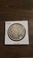 Front side of 1962 Canadian silver dollar showing canoe design and inscriptions 'CANADA DOLLAR 1962'.