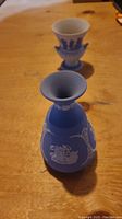 Blue jasperware vase with white classical relief designs taken from above angle showing top opening and side decorations
