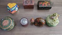 Overview of all seven small boxes on a wooden surface