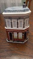 Front view of the Queen Vic cookie jar showing detailed painted brickwork, windows, door, and flower boxes.