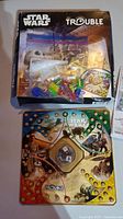 Game board laid out with colorful Star Wars themed design, clear dome die roller in center, and playing pieces in plastic bag inside box.