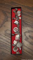 Full view of the sterling silver charm bracelet in a red box showing various charms attached.
