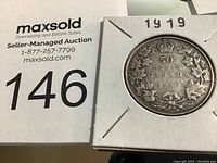 Photo showing the reverse side of the 1919 Canadian half dollar coin featuring the denomination, year, and maple leaf design