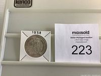 Photo of the 1958 Canadian Silver Dollar front side showing standing figure design and the year 1958.