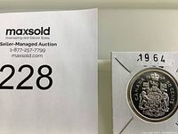 Photo of the front of the 1964 Canadian Silver Half Dollar showing the detailed coat of arms and coin markings.