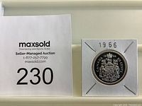 Photo of the 1966 Canadian half dollar silver coin in a protective cardboard holder with MaxSold auction number 230.