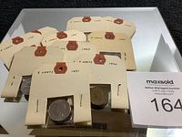 Collection of five Canadian five cent coins in paper flips with visible years: 1942, 1943, 1951, and others.