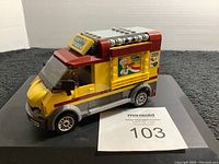 Side angle of closed Lego City pizza van showing branding and roof details
