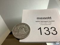 Photo showing the Liberty Bell side of the US Half Dollar coin with auction lot number 133.