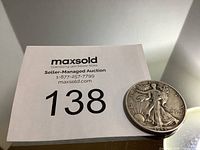 Photo showing the 1944 US half dollar Walking Liberty coin with auction lot number 138 card.