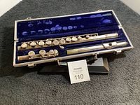 Flute disassembled in case showing keys and parts.