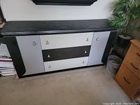 Front view of the customized buffet cabinet/dresser showing black and white finish and multiple drawers and doors.