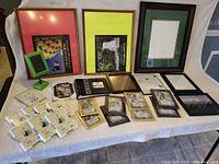 Wide view of the collection of various sized frames and posters arranged on a white cloth.