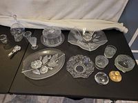 Wide view of entire lot showing all glass and crystal dishes, bowls, skull decanter, and opener