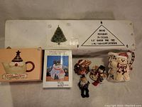 Photo showing entire lot including boxed 4.5' Glacier Pine artificial Christmas tree, Santa teapot box, metal lantern candle holder in snowman shape, four snowman figurines, and gingerbread-shaped pitcher.