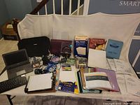 Overview of Acer laptop, carrying case, assorted peripherals, recordable media discs, and office stationery items spread out on a surface.