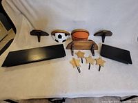 Photo shows assortment of wall shelves, mounting brackets, and star-shaped hooks on light fabric background.