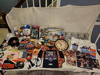 Wide view of lot showing a variety of sports memorabilia on a cloth backdrop.