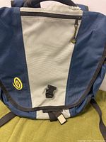 Front view of Timbuk2 backpack pannier in blue and white with zipper and buckle closure